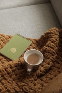 Libreta y taza de café que representan un momento de reflexión durante un proceso terapéutico.